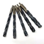 Six dark metal twist drill bits in assorted sizes arranged in a fan-like grouping against a plain white background.